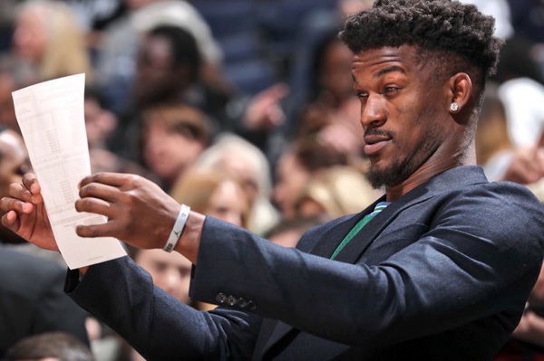 Jimmy Butler reading a book courtside